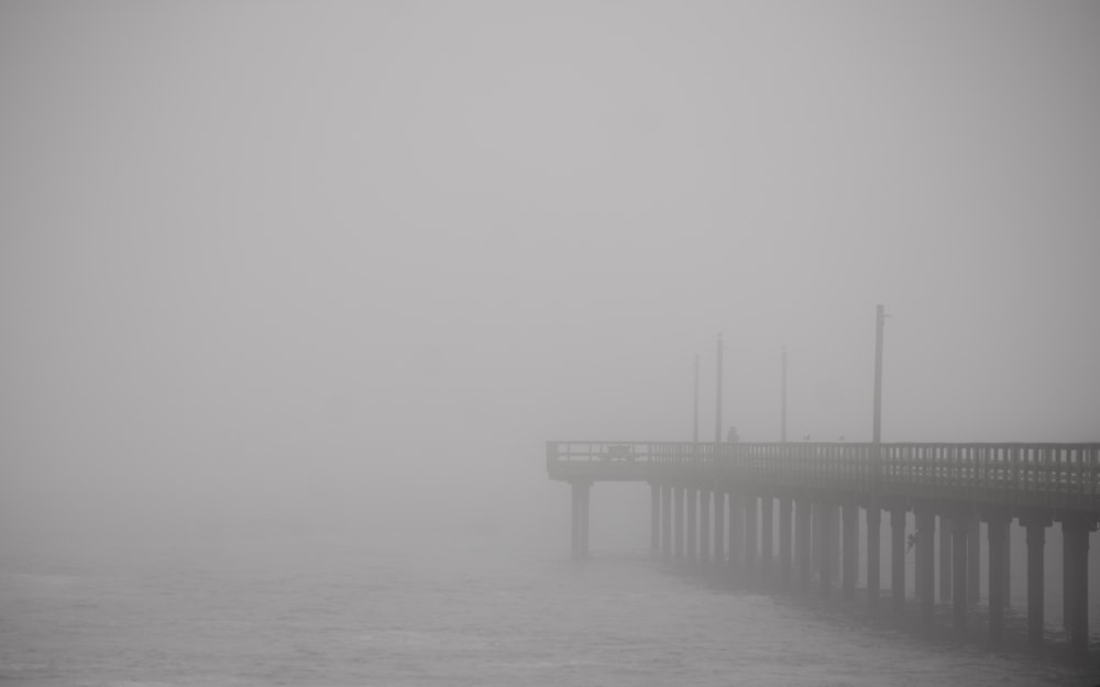 a long pier on a foggy day in the ocean