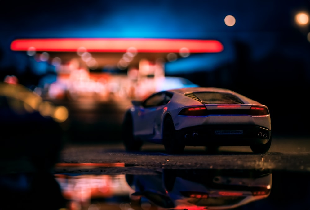 a toy car is parked in front of a gas station