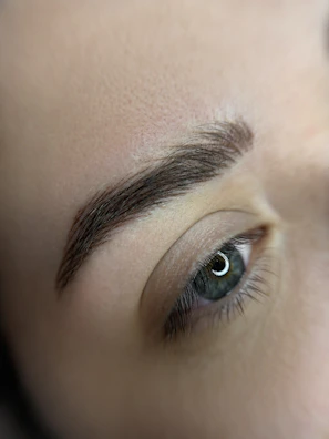 a close up of a person's eye with a pair of scissors