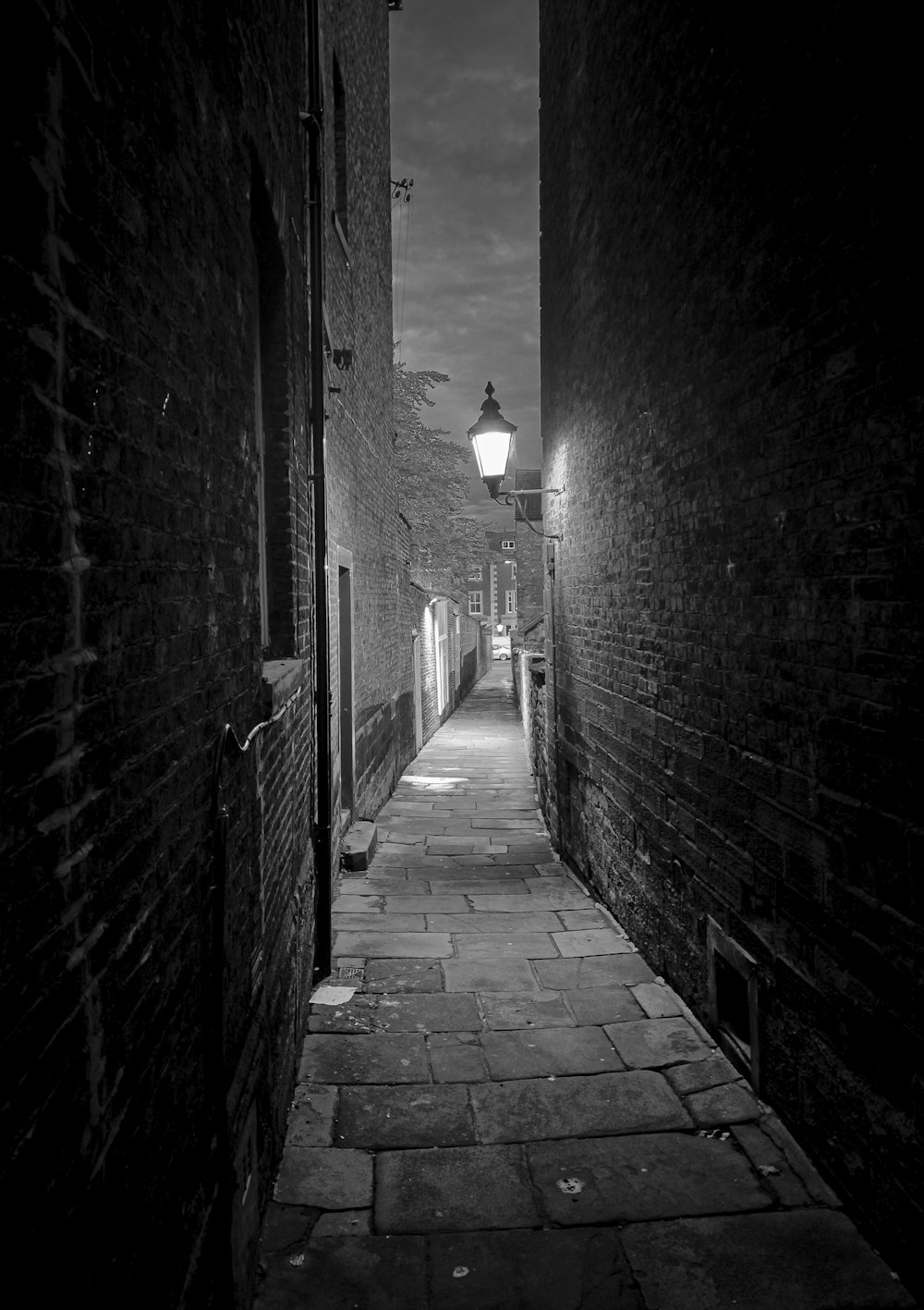 a dark alley way with a street lamp