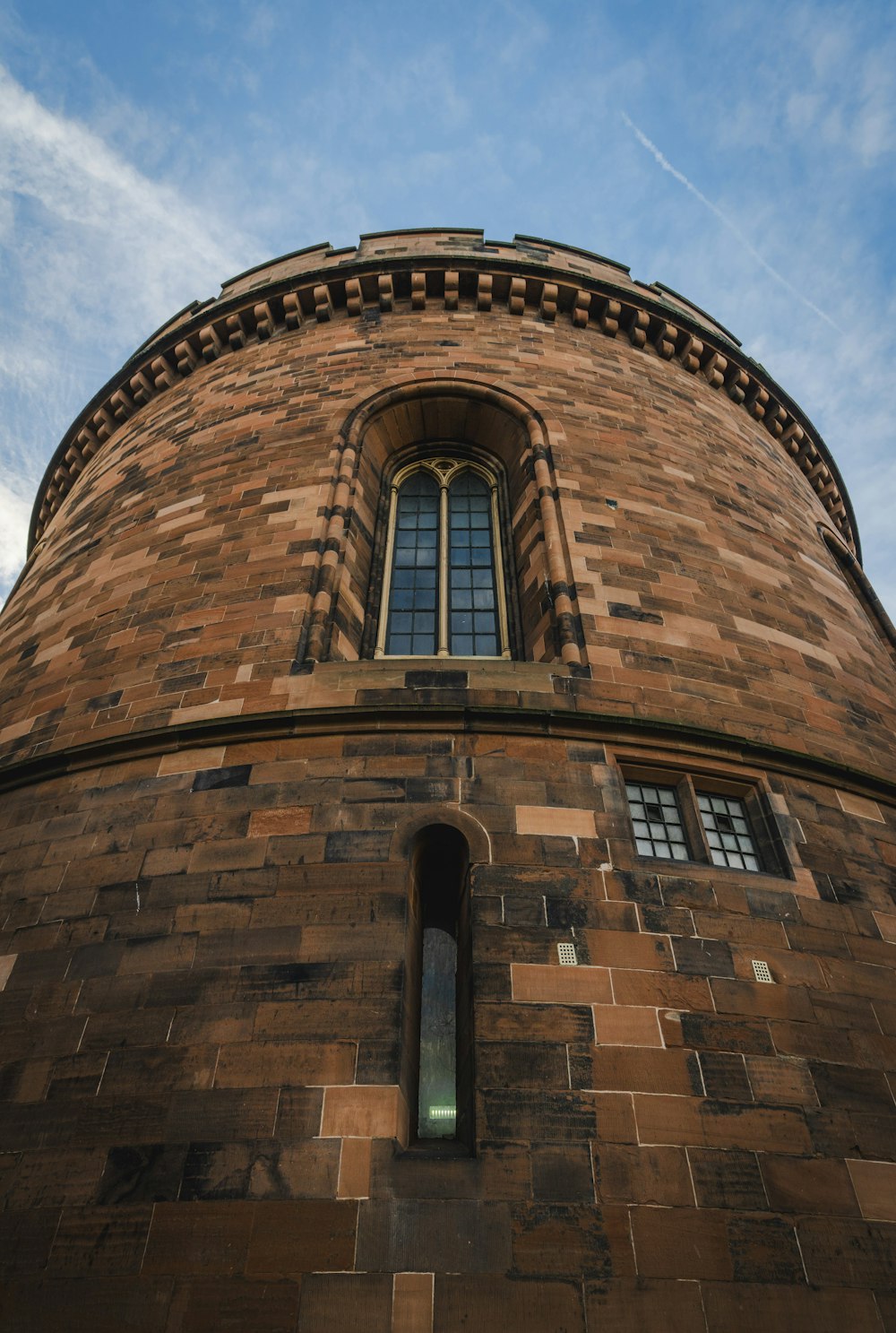 a very tall brick building with a sky background