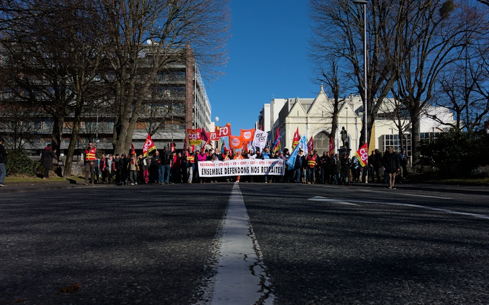 a group of people standing on the side of a road