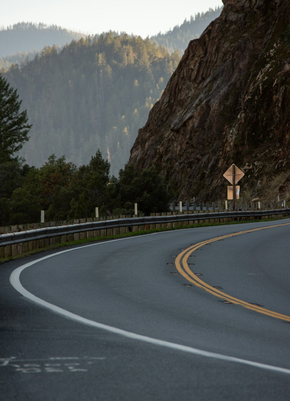 a curved road with a mountain in the background