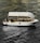 A stylish white boat with a canopy is sailing on textured, dark water. Several people are onboard, one of whom is raising their hand. The boat interior includes tables and chairs, suggesting a relaxed or leisure setting. Ambient lighting highlights the contours of the boat.