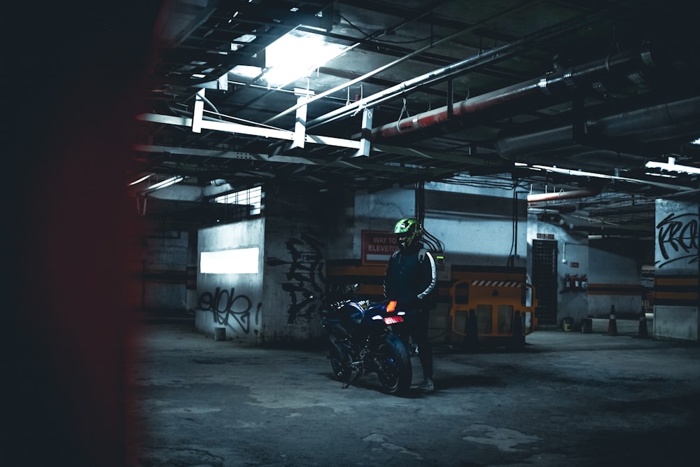 a man standing next to a motorcycle in a garage