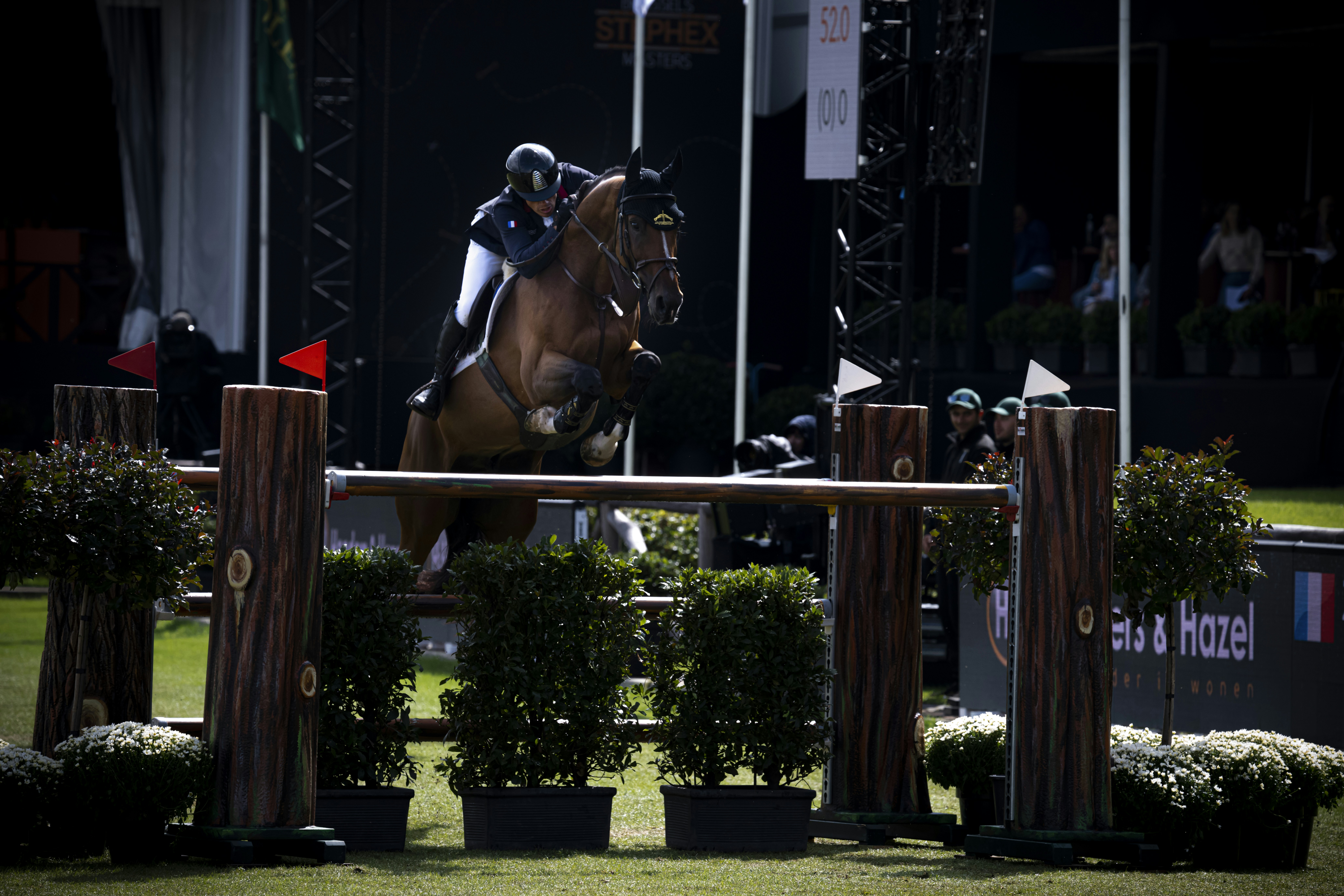 a person on a horse jumping over a fence