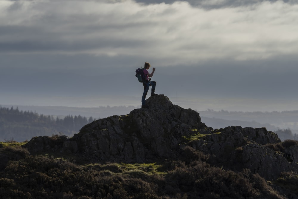 una persona in piedi sulla cima di una montagna con uno zaino