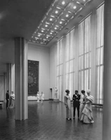 Elegant guests mingling in a sophisticated venue with contemporary architectural elements.