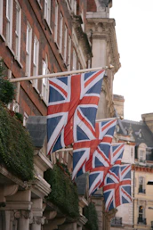 a row of british flags hanging from the side of a building