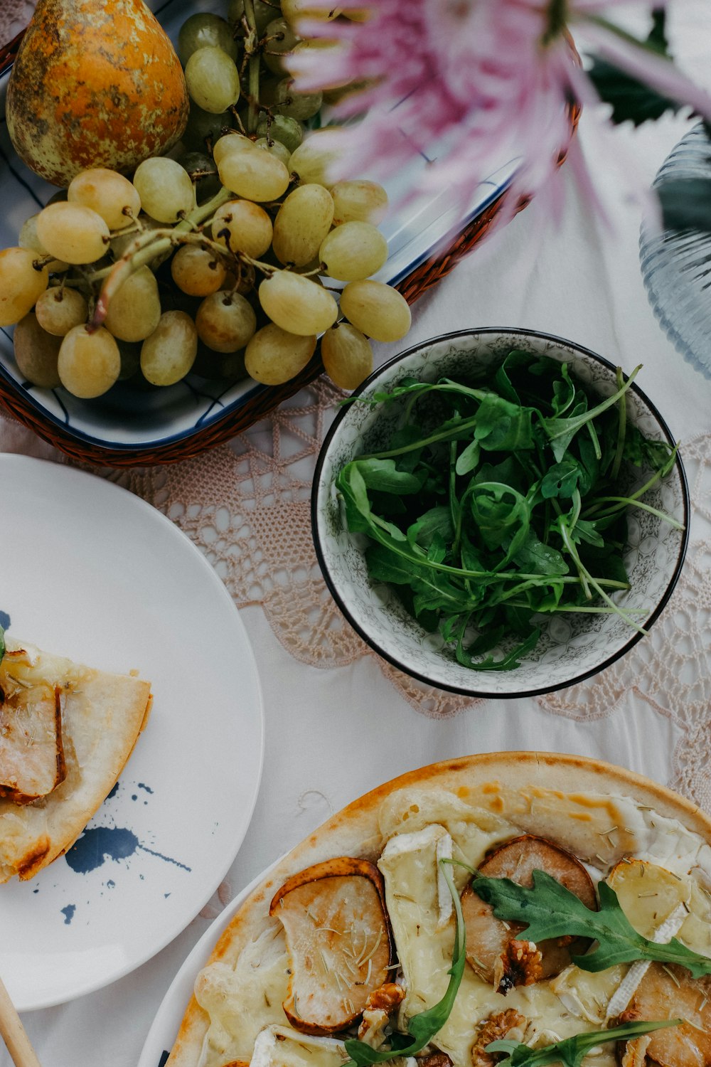 a table topped with plates of food and a bowl of fruit