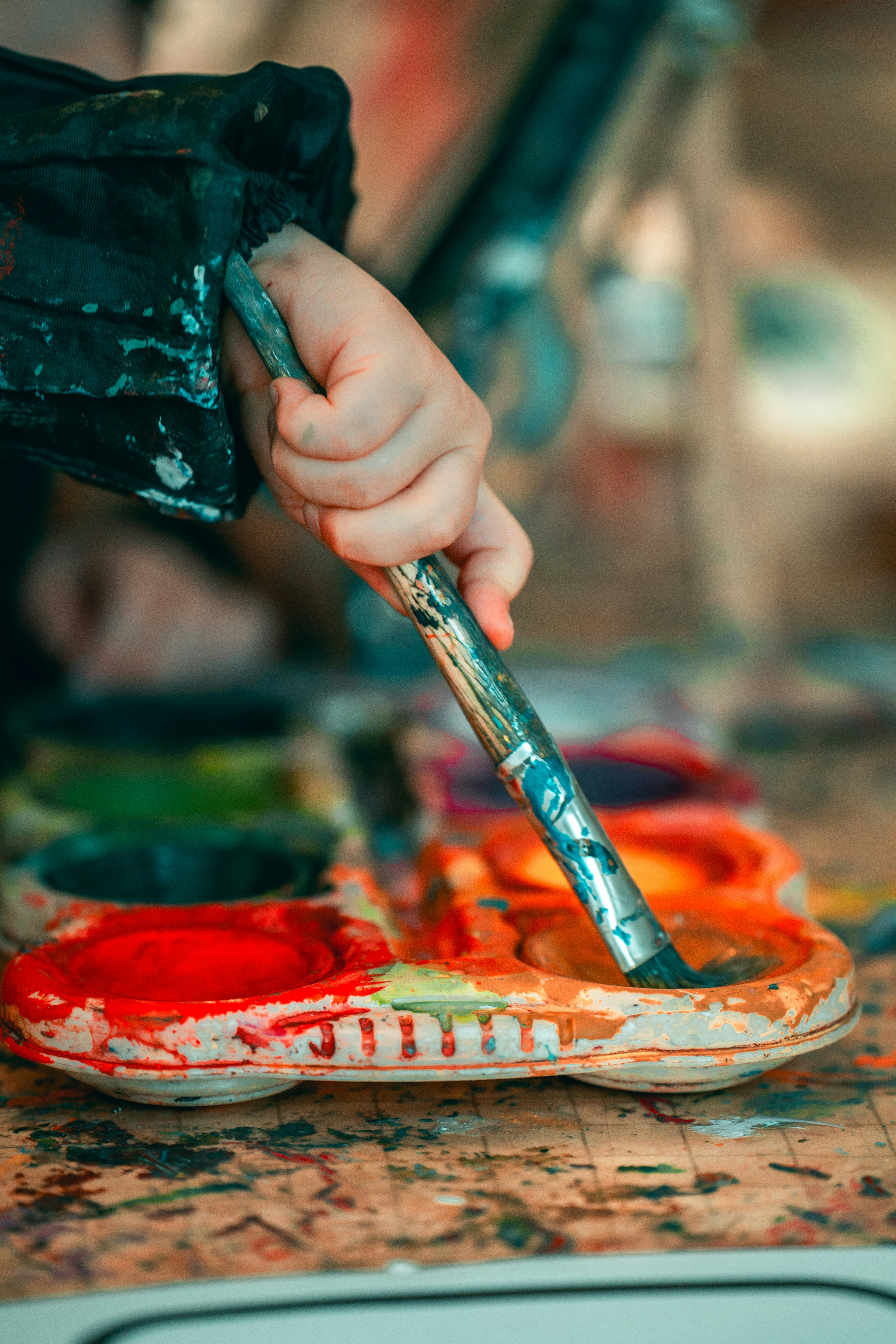 a person holding a paintbrush and painting on a piece of art