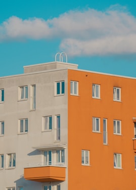 a tall orange building sitting next to a tall white building