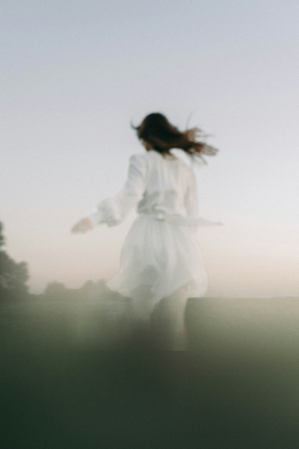 una foto sfocata di una donna con un vestito bianco