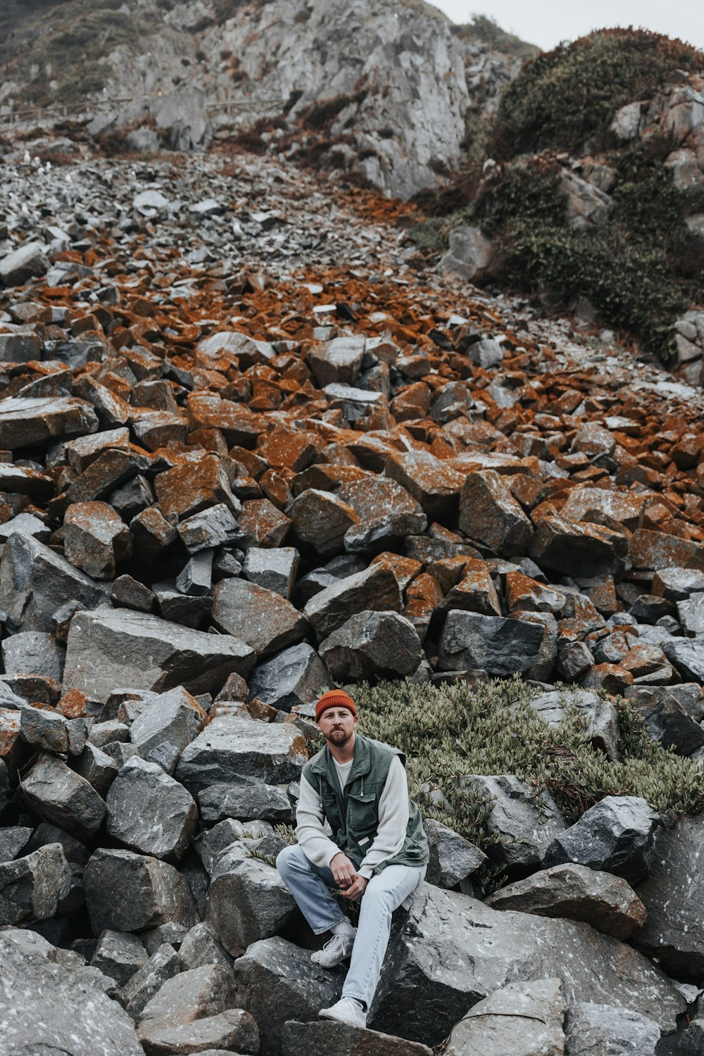a man sitting on a pile of rocks