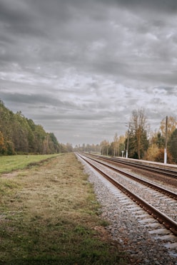 a train track with a cloudy sky in the background