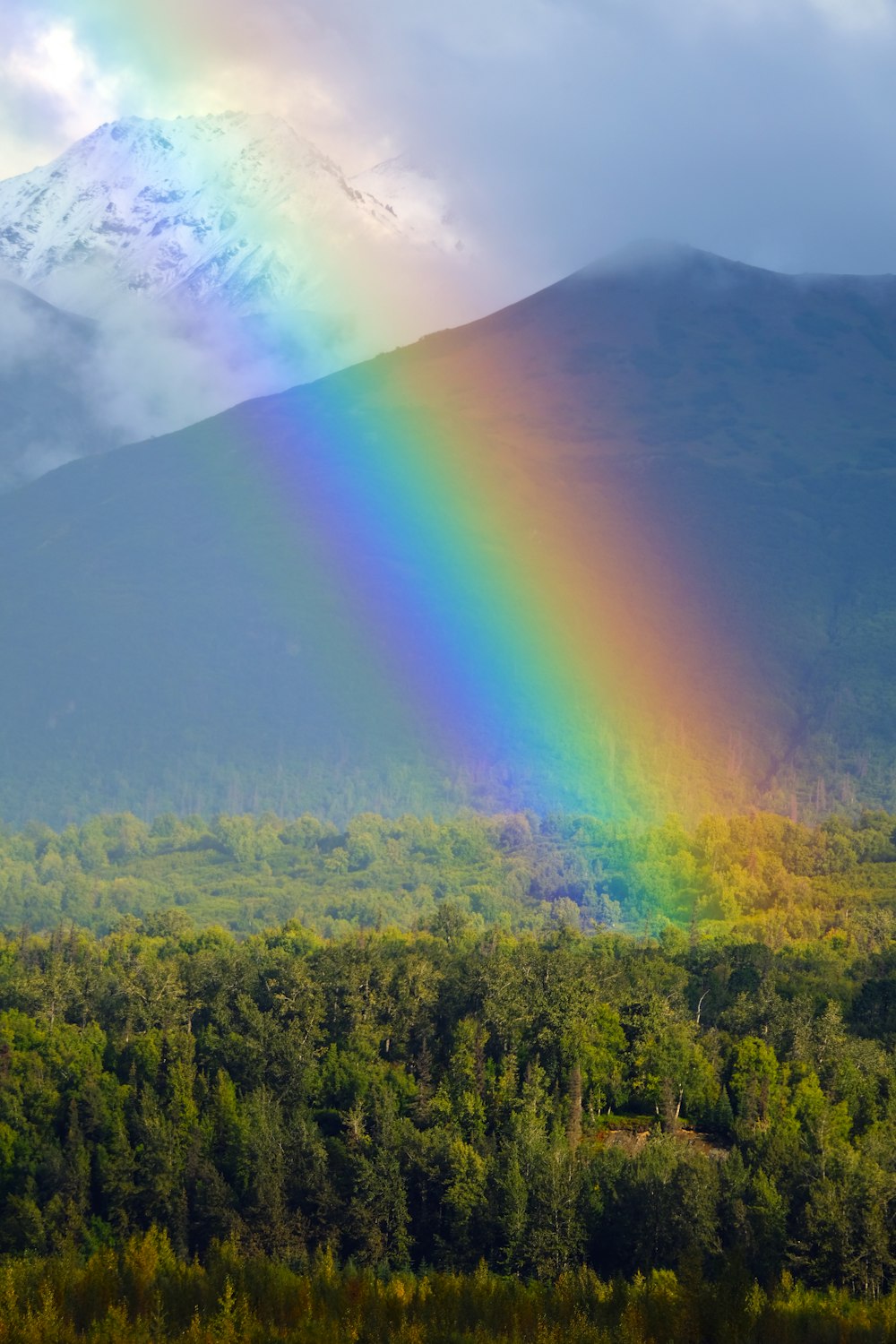 a rainbow in the sky over a mountain range