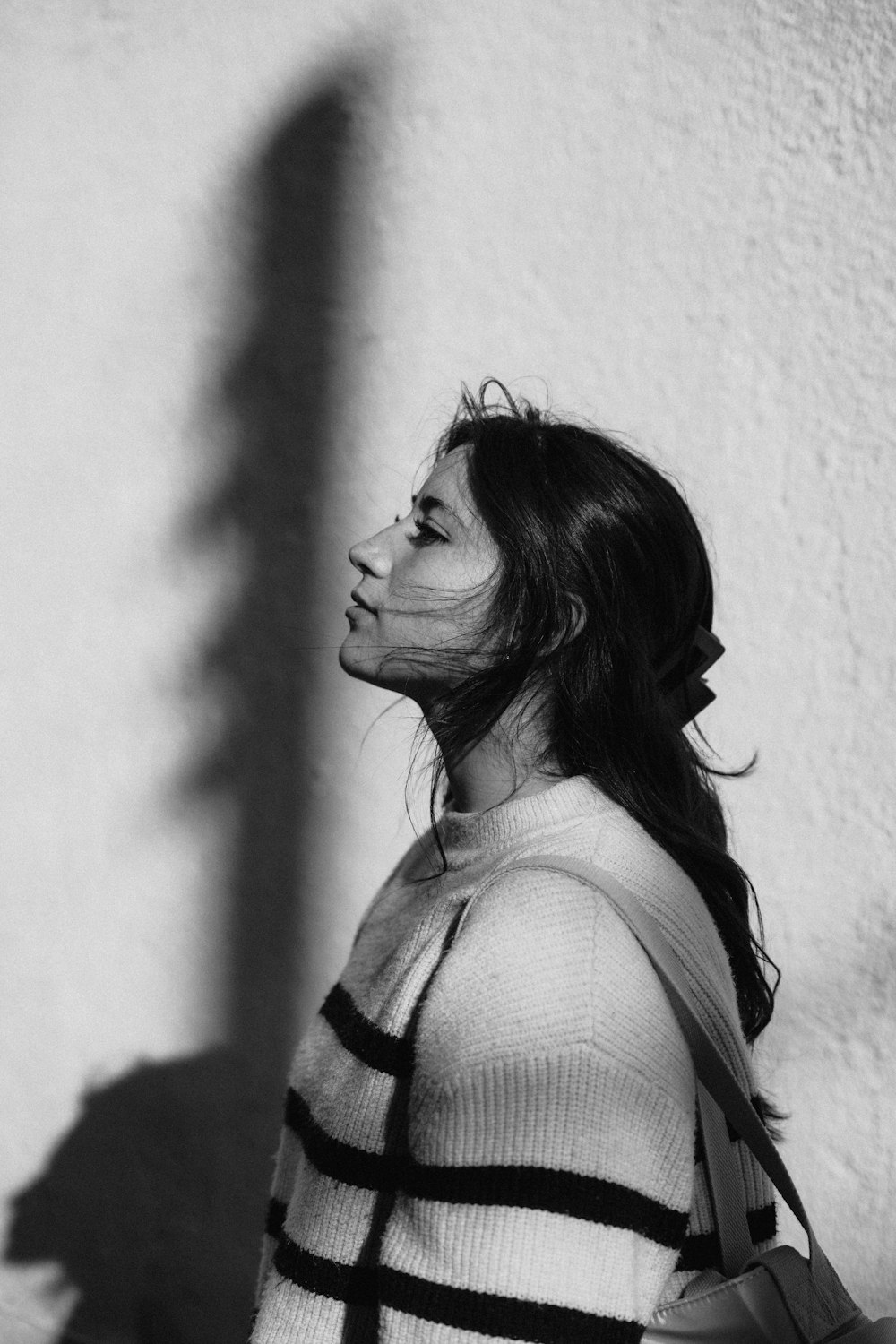 a woman standing in front of a white wall