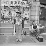 A small business owner proudly standing outside their shop with a Farm Home Finance sign