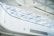 An interior space featuring a modern architectural ceiling design with a large skylight composed of triangular glass panels. The ceiling is primarily white, with a clean and minimalist appearance. Sunlight filters through the glass, casting geometric shadows on the surfaces below.