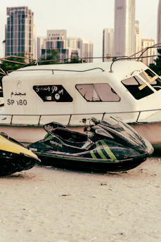 A sleek gold jet ski gliding over dark, shimmering water under Dubai's night skyline.
