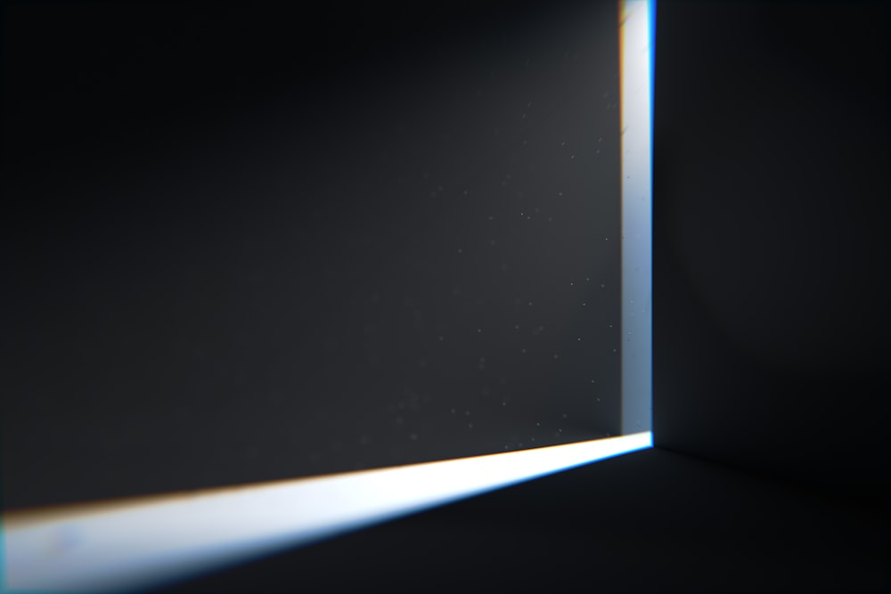 a light shining through a window in a dark room