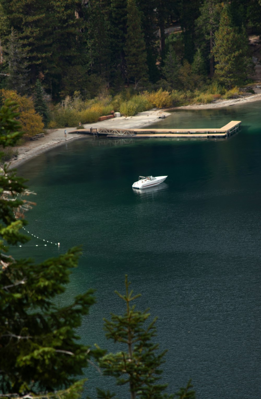 a boat floating on a lake surrounded by trees