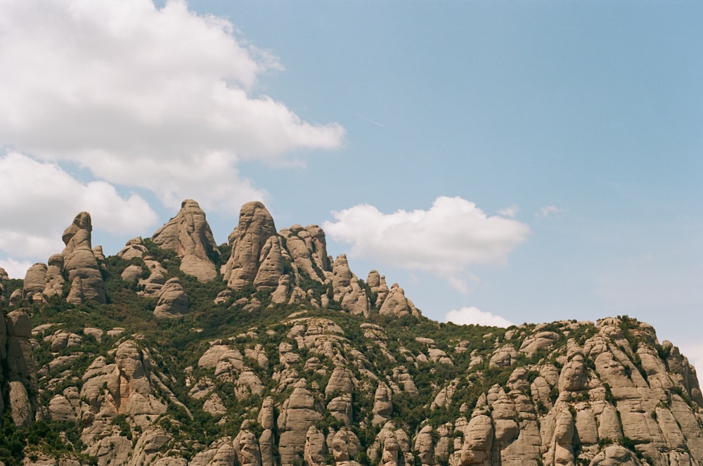 a rocky mountain with a few clouds in the sky