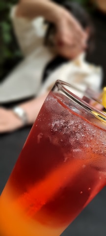 Close-up of a colorful fresh fruit juice in a glass with condensation