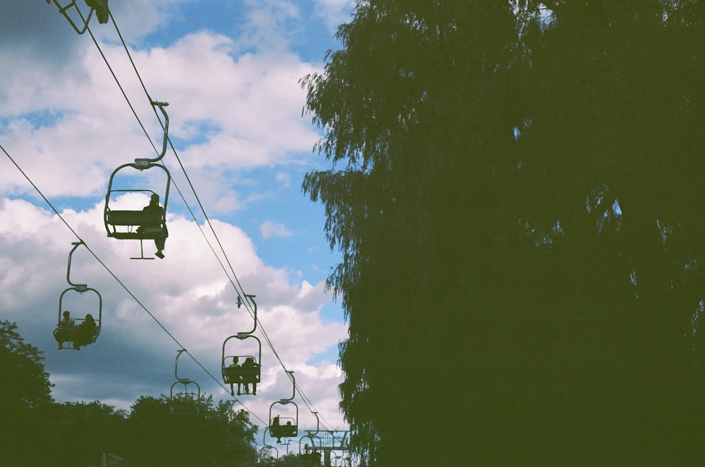 a group of people riding a ski lift on a cloudy day