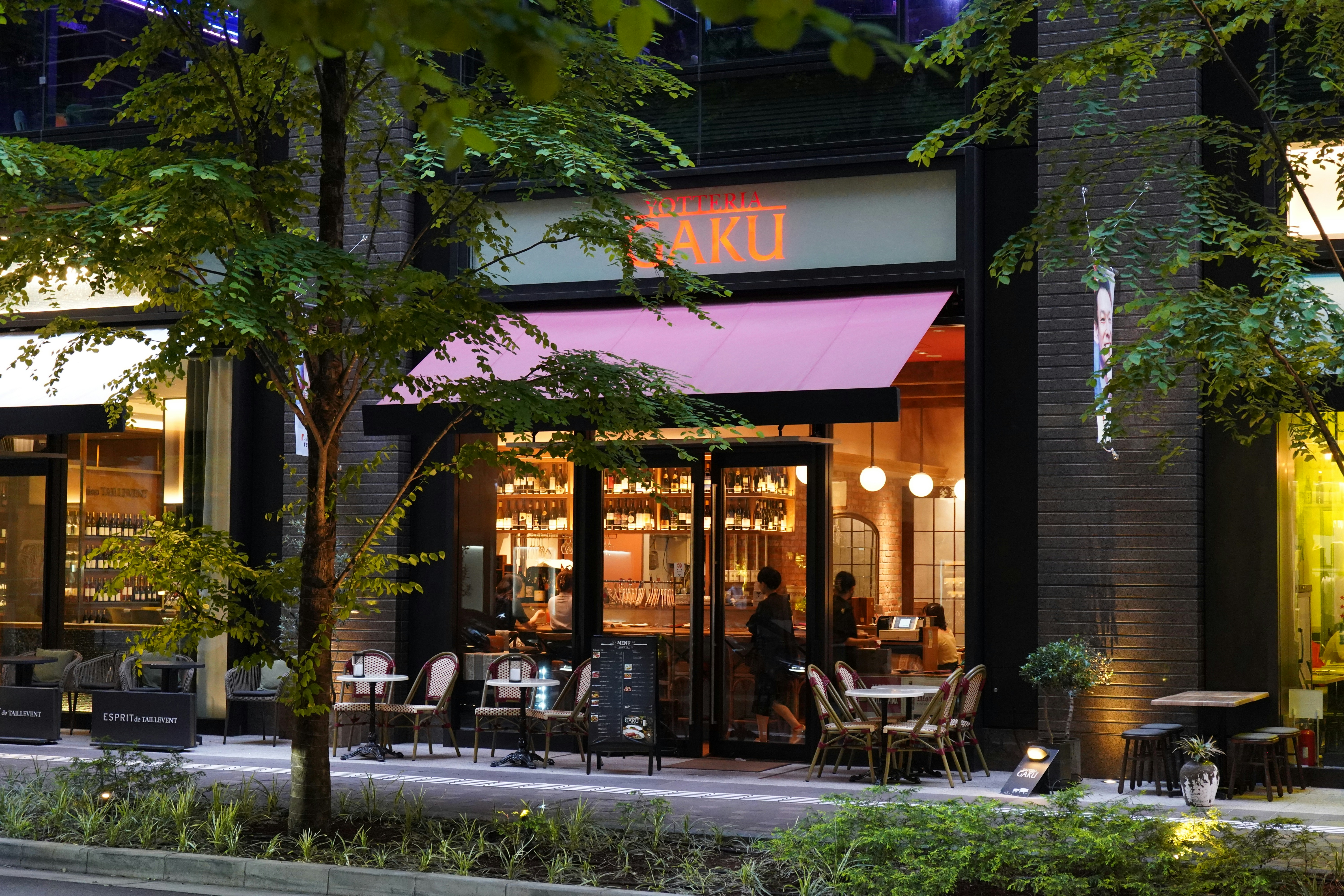 Un restaurante con un toldo rosa en el exterior