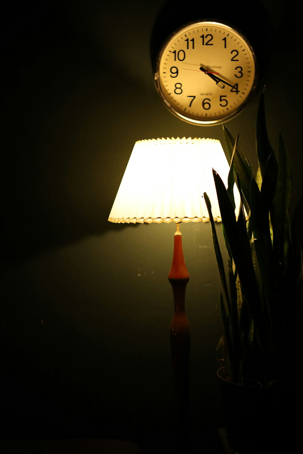 a lamp that is next to a clock on a wall