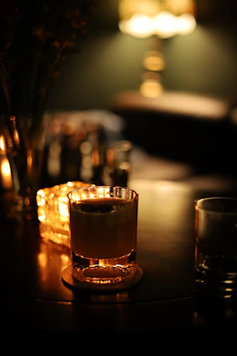 Artful arrangement of whiskey smokers with amber gold accents against a soft light gray background.