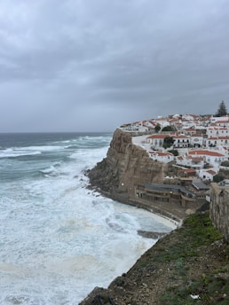 A coastal village with reinforced homes and community members preparing for storms.