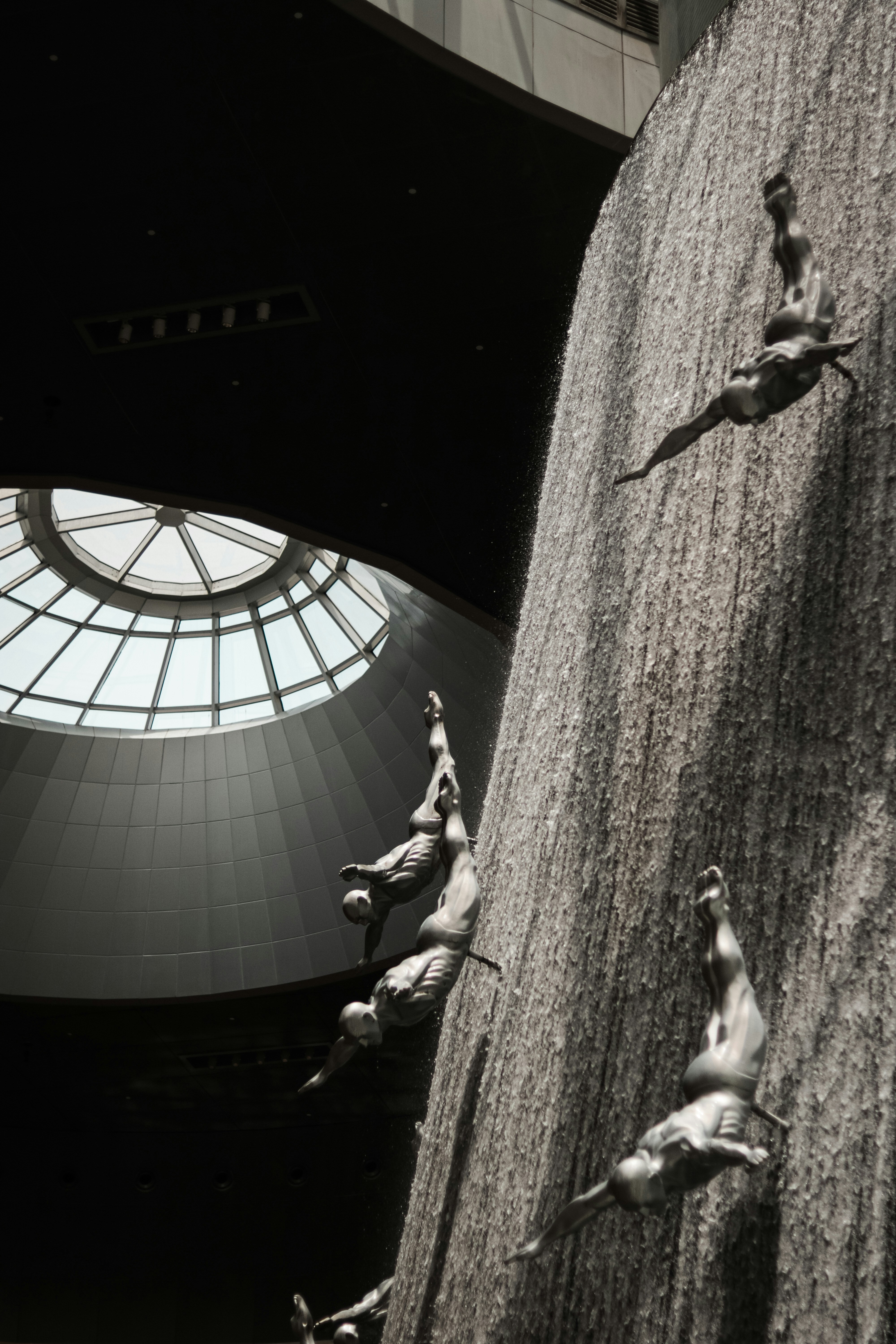 a black and white photo of a man climbing a wall