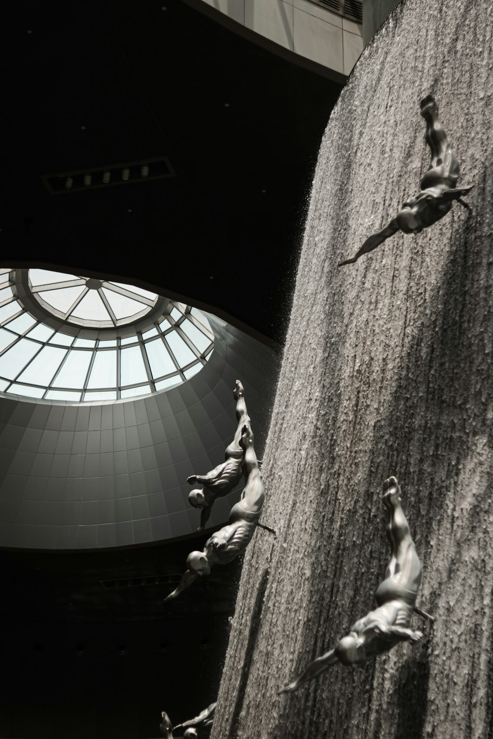 a black and white photo of a man climbing a wall