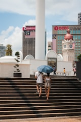 two people walking up some steps with an umbrella
