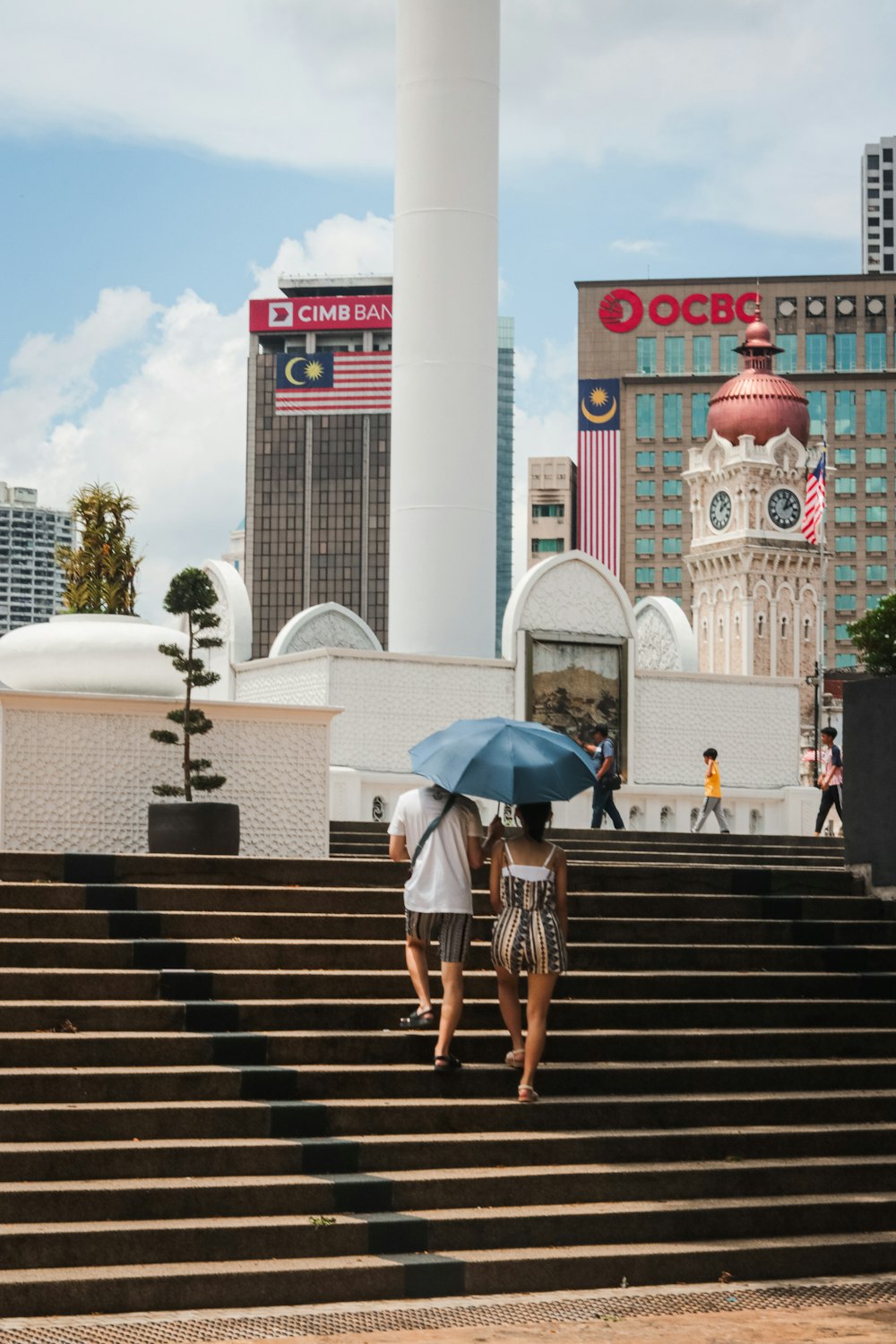 two people walking up some steps with an umbrella