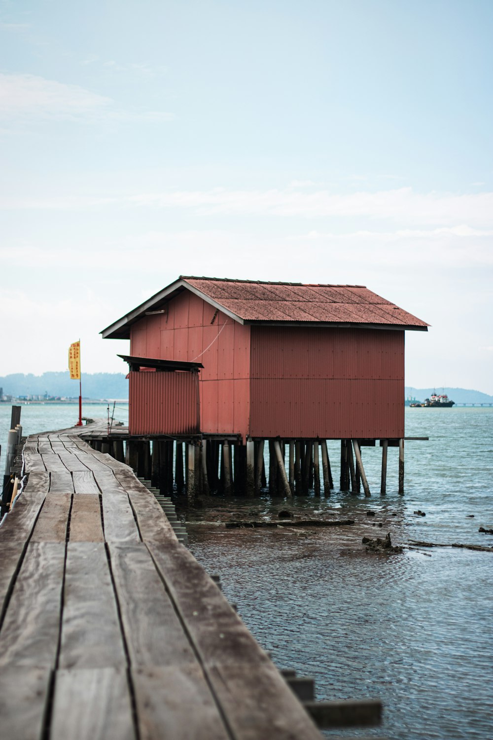 a red building sitting on top of a wooden pier