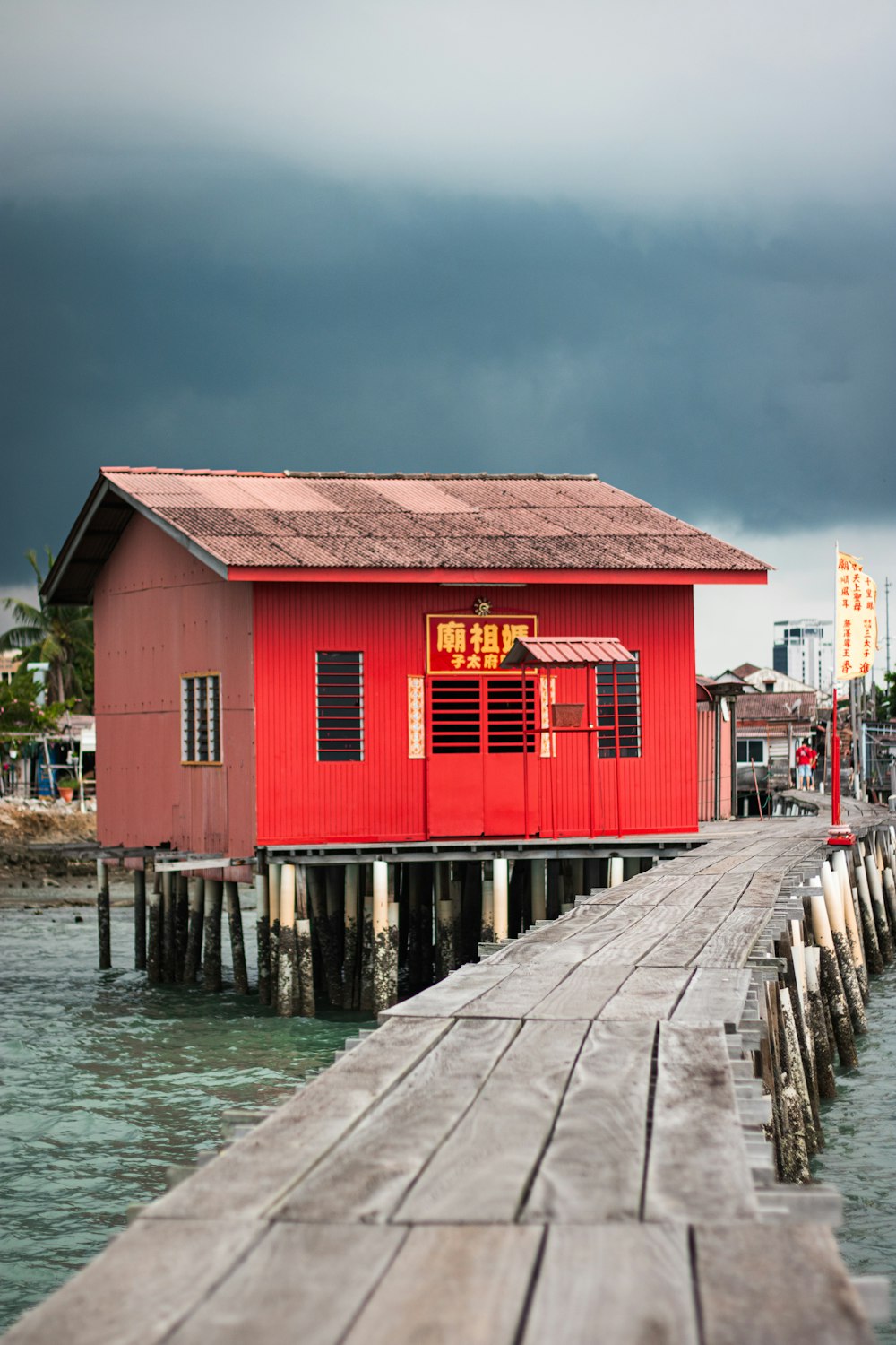 a red house sitting on top of a wooden pier