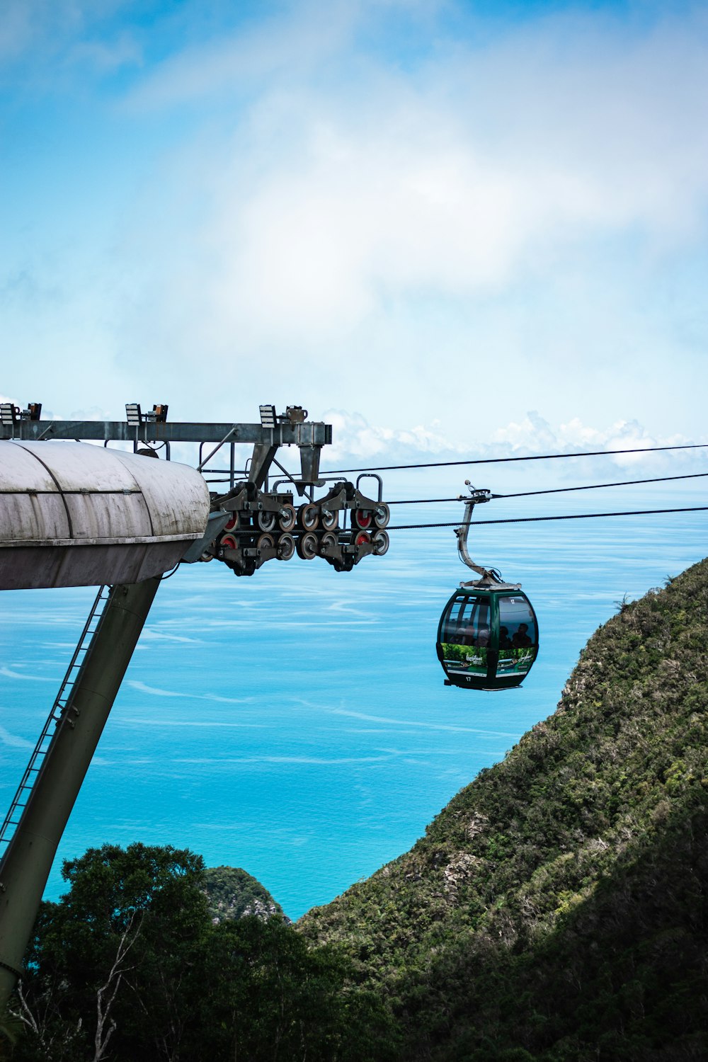 a cable car going up a hill with the ocean in the background
