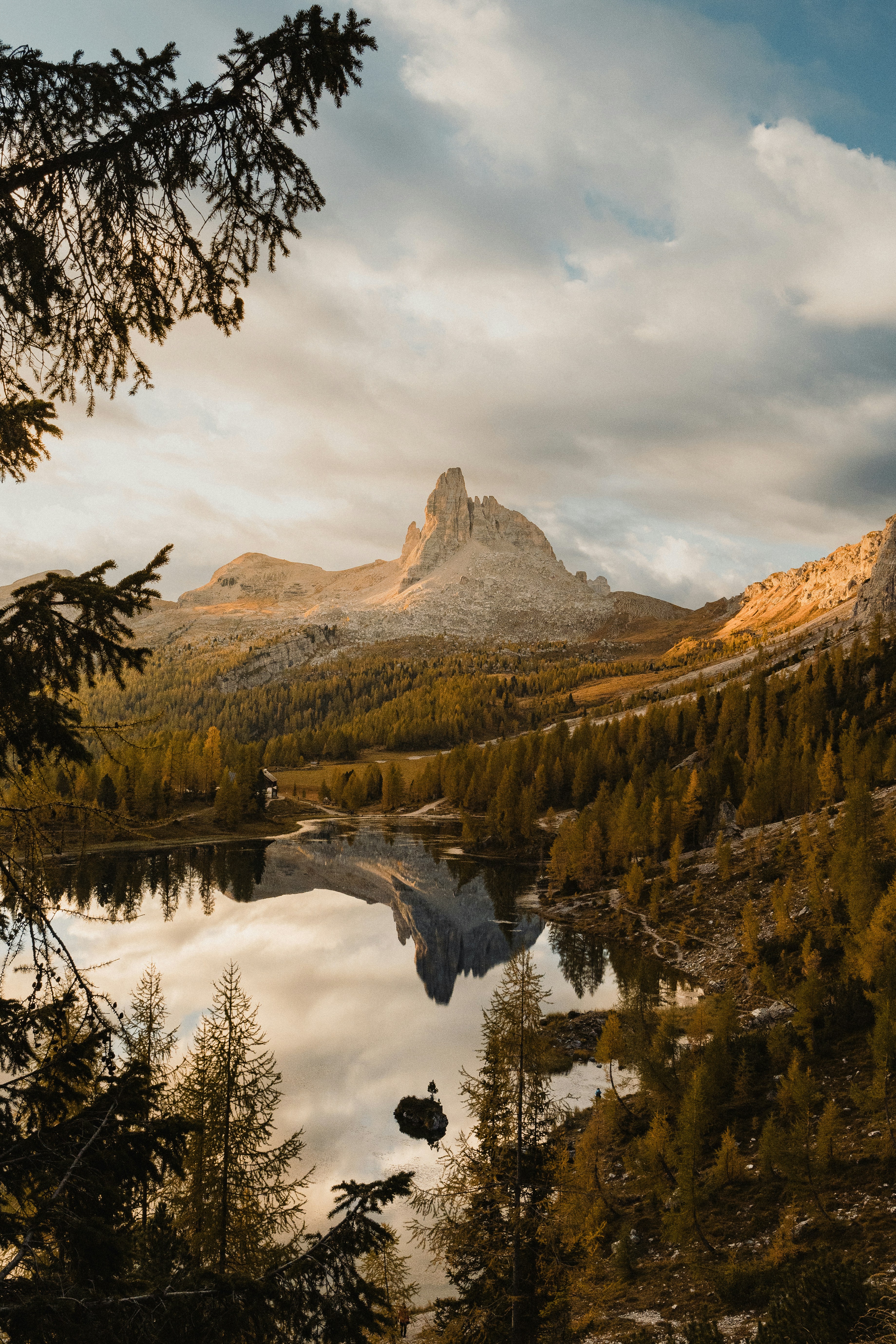 a lake surrounded by trees with a mountain in the background