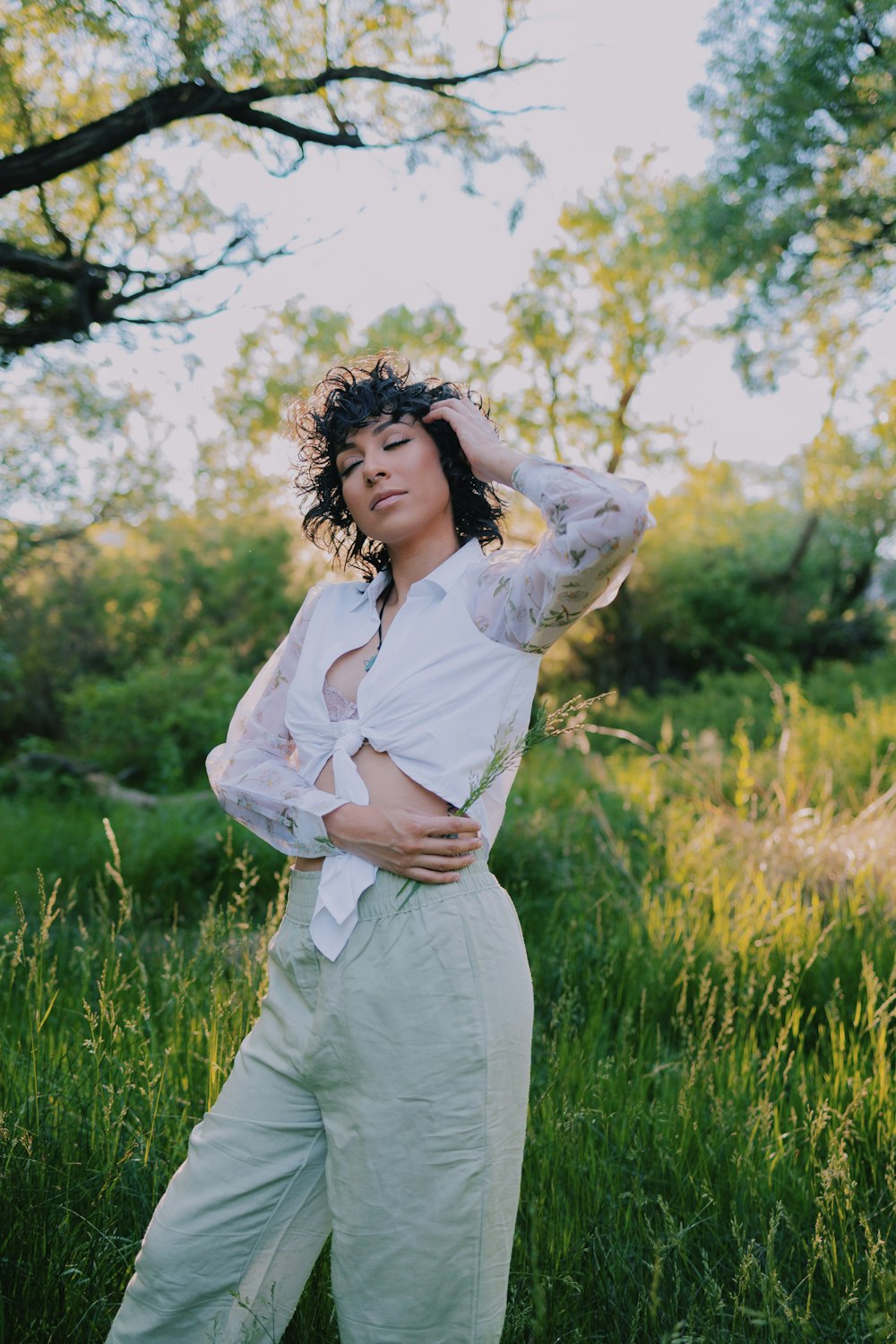 a woman standing in a field of tall grass