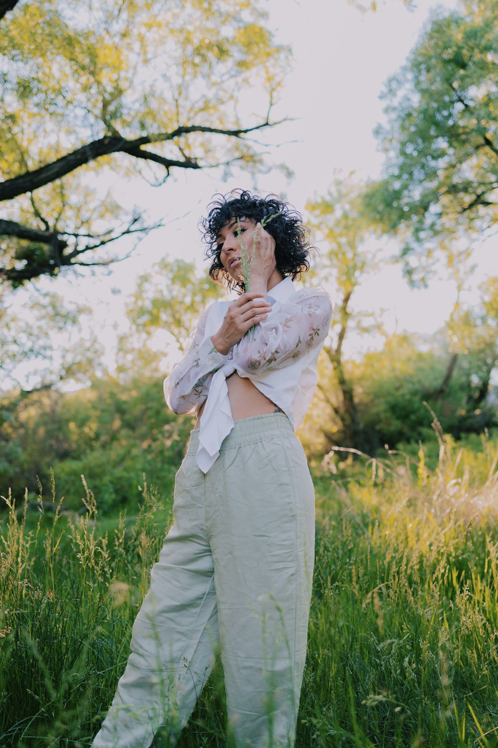 a woman standing in a field of tall grass