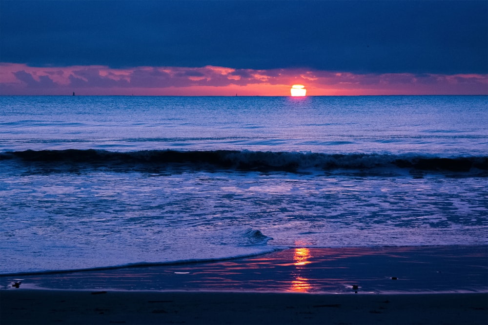 Le soleil se couche sur l’océan par temps nuageux