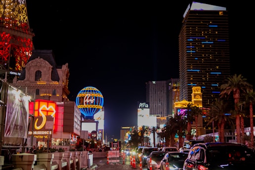 A cityscape of Las Vegas at night with emergency vehicles flashing lights on a busy street.