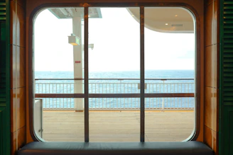 A cozy cabin on a cruise ship with a window view of the sparkling sea.