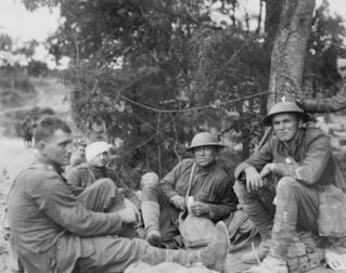 Allied soldiers, one with a bandaged head, sitting on the ground during World War I