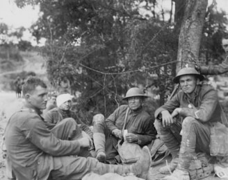 Allied soldiers, one with a bandaged head, sitting on the ground during World War I