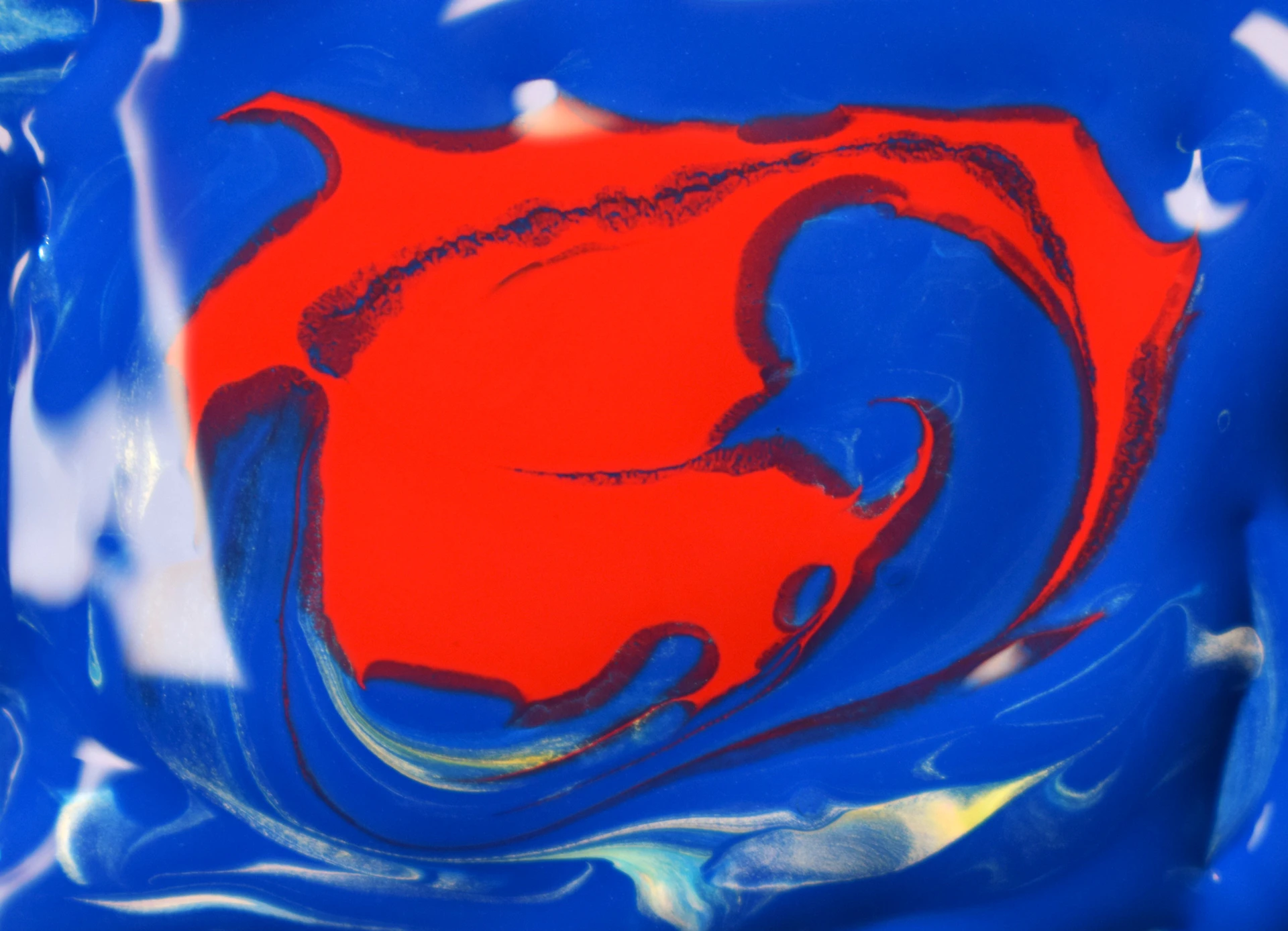 A vibrant abstract artwork bursting with bold reds and blues, set in a minimalist white frame.