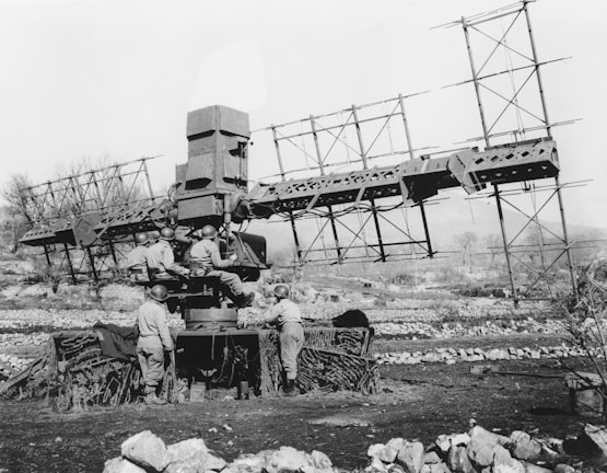 Operator in military gear monitoring counter-UAS systems in a command center with multiple screens.